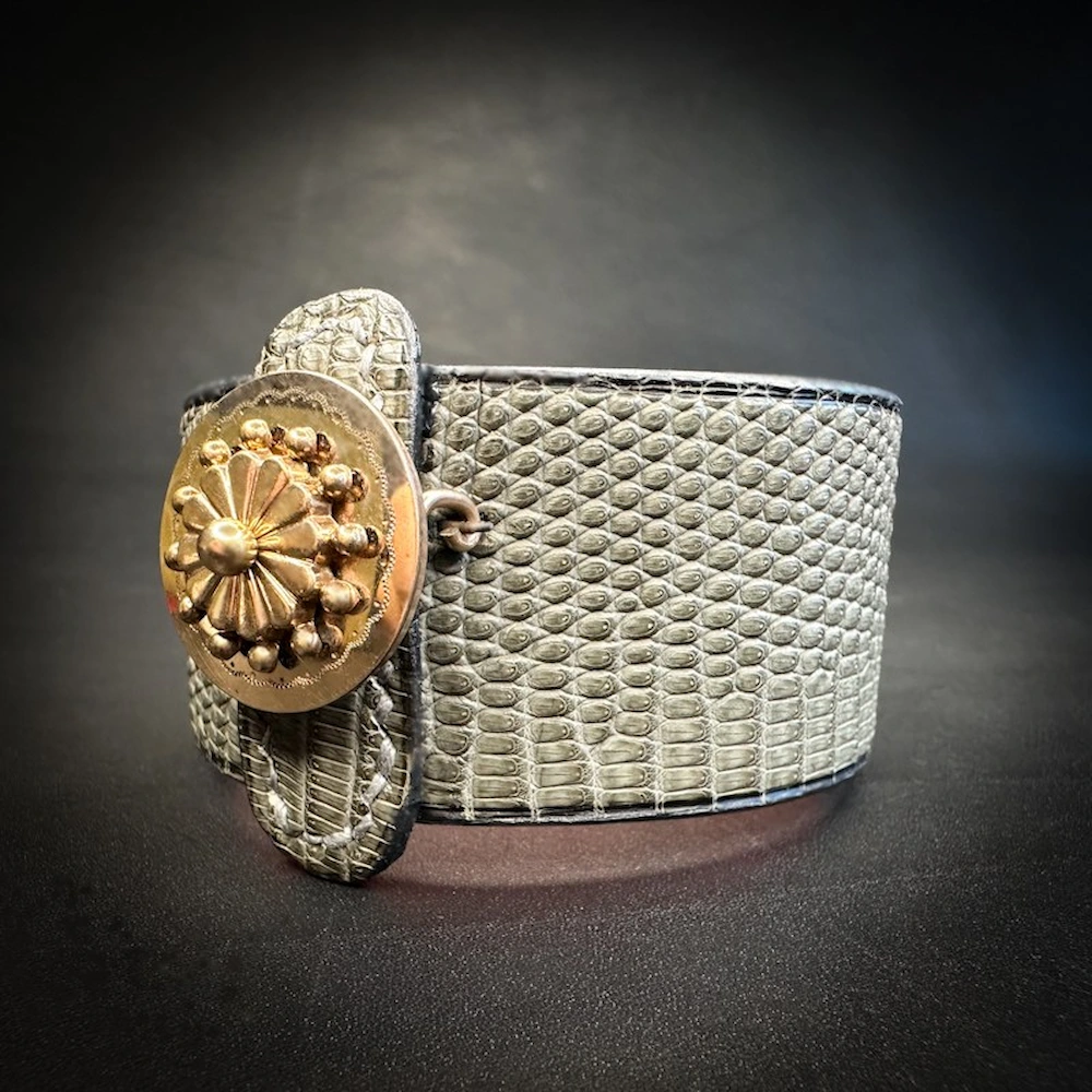 Astoria – Détail de la broche ancienne dorée sur cuir lézard sauge Astoria – Détail de la broche ancienne dorée sur cuir lézard sauge