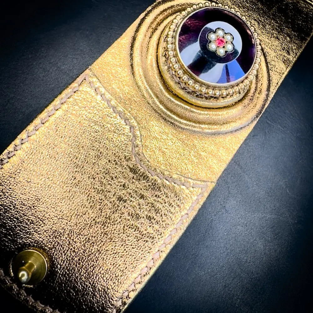 Détail du bracelet manchette cuir femme VIOLETTE en agneau métallisé or patiné avec fermeture par bouton de col en laiton Détail du bracelet manchette cuir femme VIOLETTE en agneau métallisé or patiné avec fermeture par bouton de col en laiton