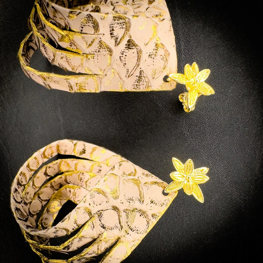 Vue d'ensemble des boucles d'oreilles en véritable python rose poudré rehaussé de touches or, réalisées à la main. Vue d'ensemble des boucles d'oreilles en véritable python rose poudré rehaussé de touches or, réalisées à la main.