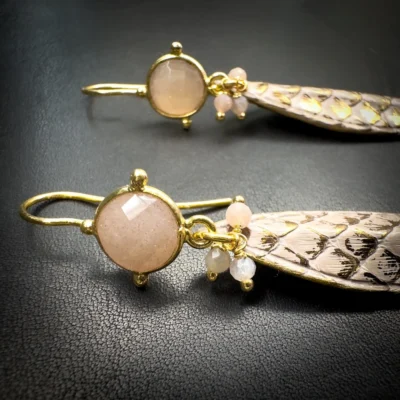 Détail de boucles d'oreilles en python rose poudré et pierre de lune rose
