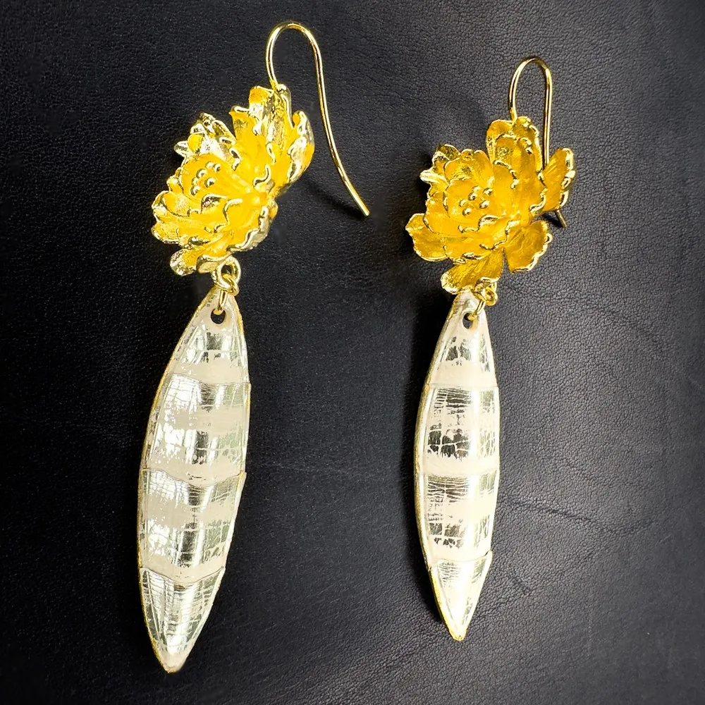 Boucles d'oreilles artisanales en python couleur sable rehaussé de touches or et montées sur laiton doré à l'or fin 24 carats. Boucles d'oreilles artisanales en python couleur sable rehaussé de touches or et montées sur laiton doré à l'or fin 24 carats.