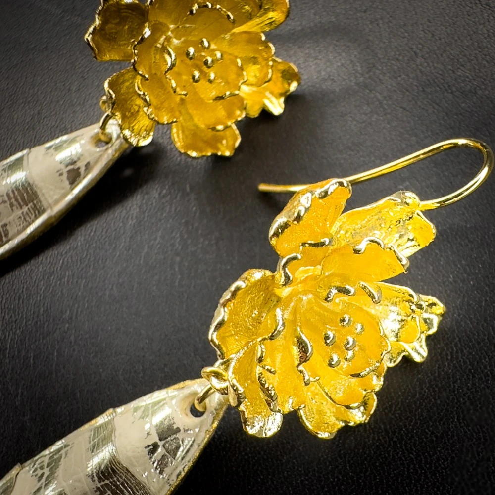 Boucles d'oreilles artisanales en python couleur sable rehaussé de touches or et montées sur laiton doré à l'or fin 24 carats, détails. Boucles d'oreilles artisanales en python couleur sable rehaussé de touches or et montées sur laiton doré à l'or fin 24 carats, détails.